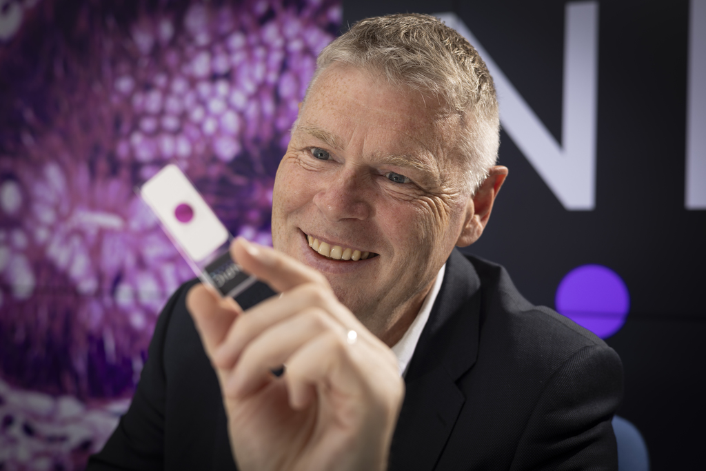 Professor David Brettle, Chief Scientific Officer at Leeds Teaching Hospitals NHS Trust with pathology slides showing the TANGO technology.
